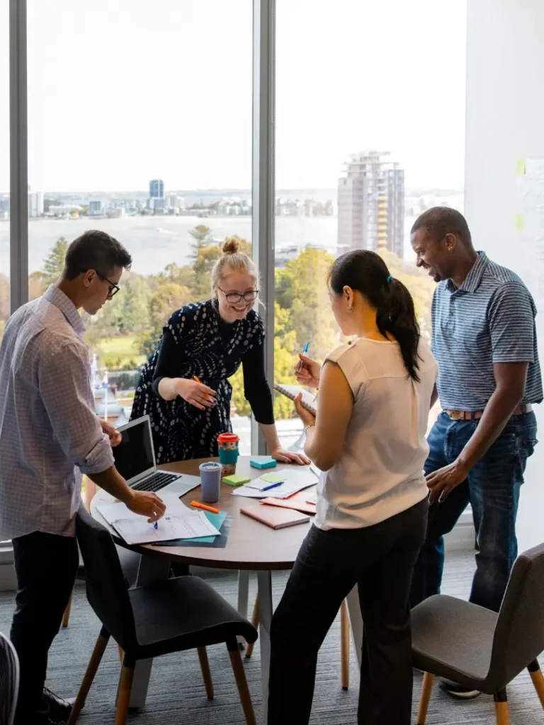 Tiimi työskentelee yhdessä projektin parissa modernissa toimistossa – yhteistyö ja suunnittelu