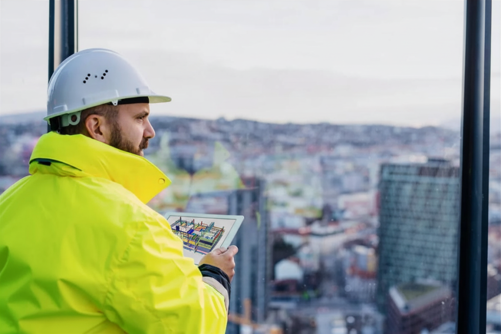 Rakennusasiantuntija valvoo työmaata tabletilla ja hyödyntää Tilavistan digitaalista dokumentointia korkeasta näköalasta.